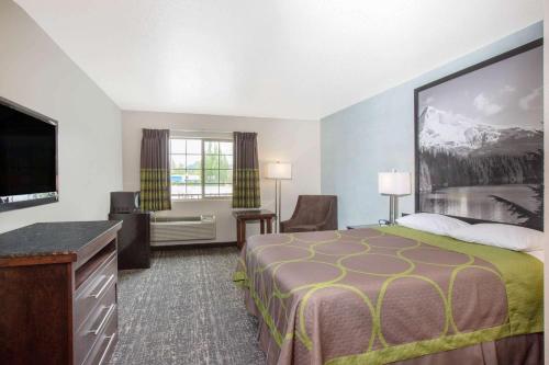 尤金Gateway Inn & Suites Eugene-Springfield的配有一张床和一台平面电视的酒店客房