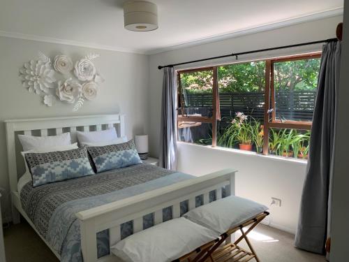 帕拉帕拉乌穆Twin Oaks Quiet Cottage的一间卧室设有一张大床和一个窗户。
