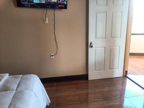 圣佩德罗拉拉古纳Millennium Apartment的卧室设有门,墙上配有电视
