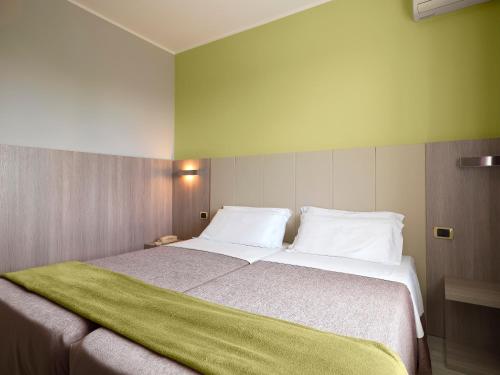 博尔戈马内罗Hotel San Francesco的一间卧室配有一张大床,上面有绿毯