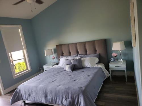 West KelownaWine Country Luxury Waterfront Condo的一间卧室配有一张带蓝色墙壁的大床