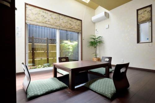 京都雅度假屋的一间带桌椅和大窗户的用餐室