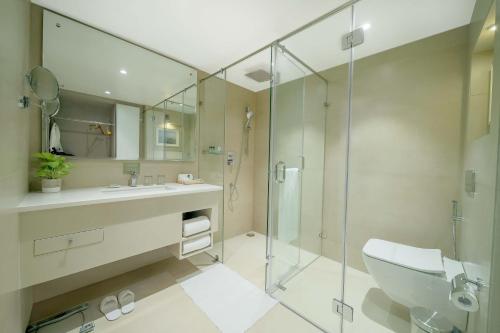维杰亚瓦达Jade Suites - Luxury Boutique Hotel的带淋浴、盥洗盆和卫生间的浴室