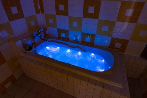 天理市Koriyama Flower Style的铺有瓷砖的浴室内的蓝色浴缸