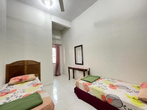 瓜拉丁加奴Near Beach and Airport - Ivana Homestay Unit C1的一间卧室配有两张床和一张桌子