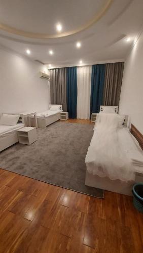 塔什干GUESTO HOSTEL的大房间设有两张床和一张沙发