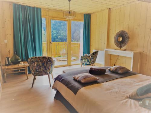 Aillon-le-JeuneLe Chalet Du Blanc Spa yoga的一间卧室设有一张大床和一个大窗户