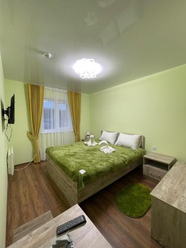 SukhostavГотель ТІК Копичинці的一间卧室,卧室内设有一张绿色大床