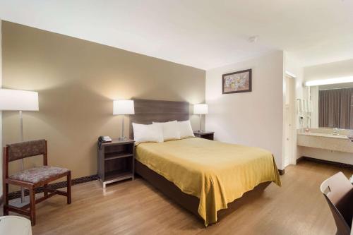 鹅溪古斯克里克伊克诺旅店的配有一张床和一把椅子的酒店客房