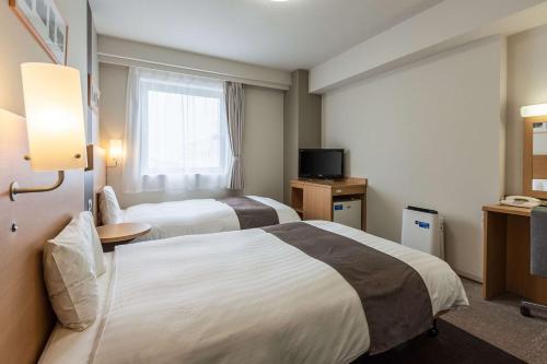 秋田秋田凯富酒店的酒店客房设有两张床和电视。
