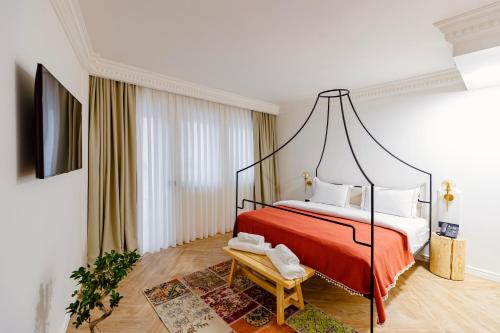 普里什蒂纳Garden Downtown Prishtina的一间卧室配有一张带红色毯子的天蓬床