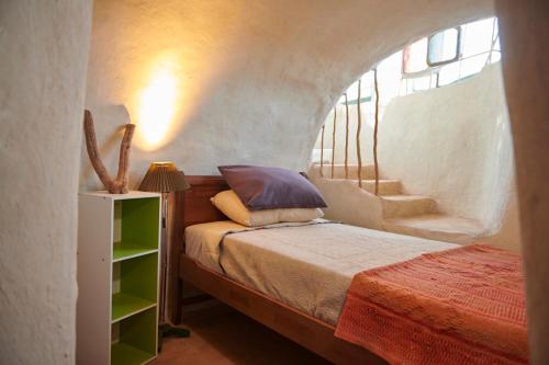 圣佩德罗·德·阿塔卡马CASA PEQUÉN的一间卧室配有一张床和一个楼梯间