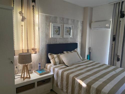 阿奎拉兹Resort Beach Place的一间卧室配有一张床和一张带台灯的桌子