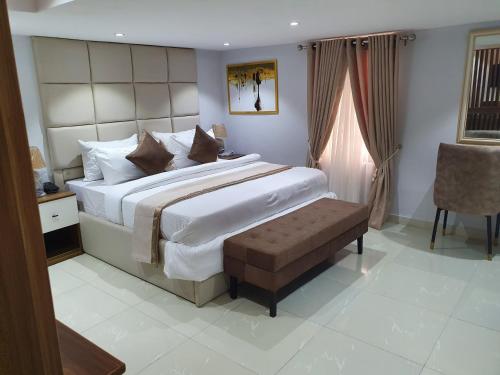 伊凯贾Choice Luxe Lagos的一间卧室配有一张大床和一把椅子