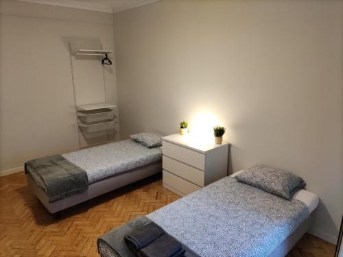 里斯本Memoria 49 - 21的一间卧室配有两张床和一个带镜子的梳妆台