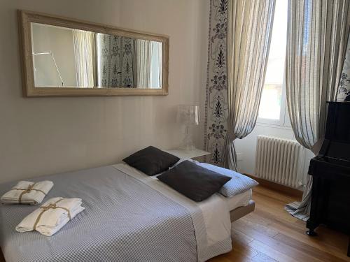 佛罗伦萨Casa Bocchi 3的卧室配有一张壁挂镜子的床