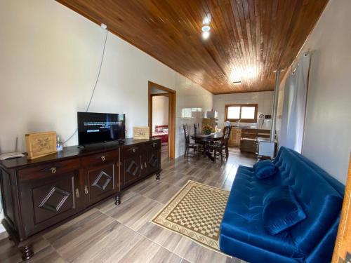 乌鲁比西Meu Cantinho Serrano的客厅配有蓝色的沙发和电视