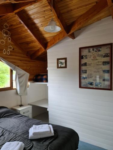 特来凡林Valle Florido的一间卧室设有一张黑色的床和木制天花板。