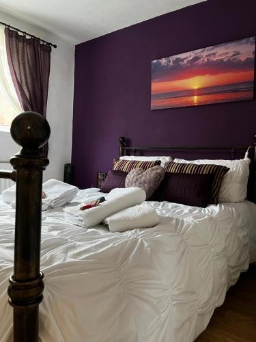 雷迪奇Home from home, close to Redditch hospital & transport links的卧室配有白色床和紫色墙壁