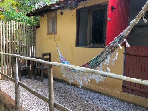 皮拉尼亚斯Pousada Trilha do Velho Chico的房屋前的吊床绑在围栏上