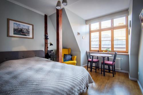 里加Langer House apartment in Old Riga的卧室配有一张床和一张桌子及椅子