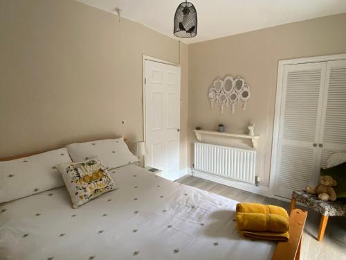 卡菲利Ty-Nance Cottage的卧室配有一张白色大床
