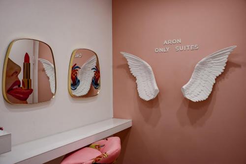 佩斯卡拉Aron Only Suites Bed and Breakfast的墙上有两面镜子和天使翅膀