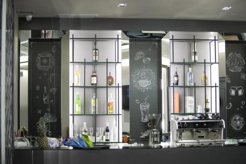 爱尔巴桑Admiral Hotel的厨房配有带瓶装酒精饮品的吧台