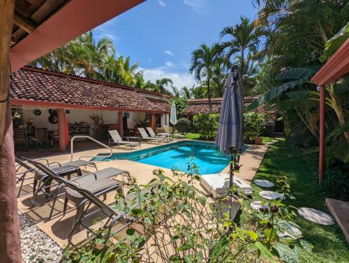 圣克拉拉Villa Botero By Casa Mojito的房屋旁的游泳池配有椅子和遮阳伞