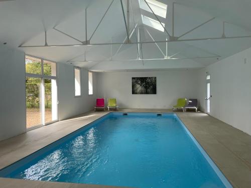 Cérans-Foulletourte多曼德贝莱酒店的客房内的大型游泳池,有蓝色的水