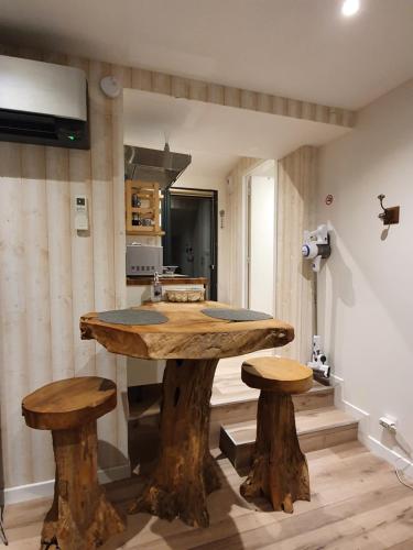拉尼翁Appartements C'Home un charme的厨房配有一张大木桌和两张凳子