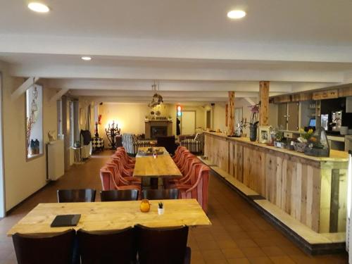 拉纳肯Vakantie Boshuisje Meibloempje的餐厅设有木桌、椅子和柜台