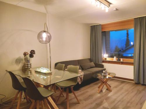 莱克斯LAAX Central Holiday Apartment with Pool & Sauna的客厅配有玻璃桌和沙发