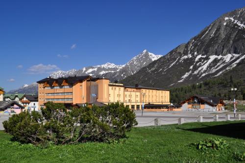 帕苏德尔托纳莱米拉蒙缇大酒店的一座大建筑,背景是群山