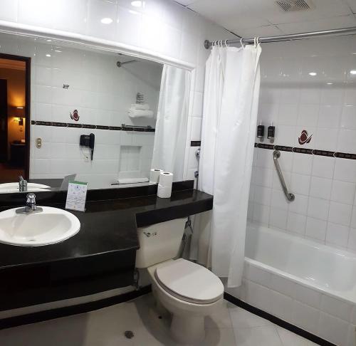 昆卡Hotel El Conquistador的浴室配有卫生间、盥洗盆和浴缸。