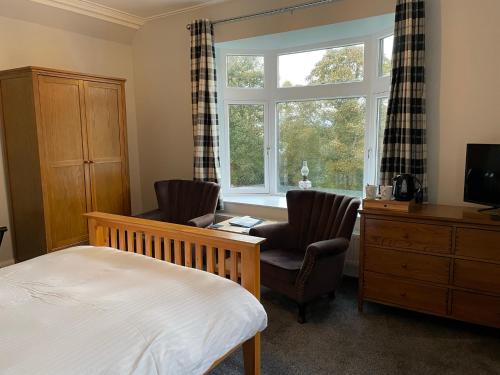 泰恩Shandwick House的一间卧室配有一张床、两把椅子和一个窗户