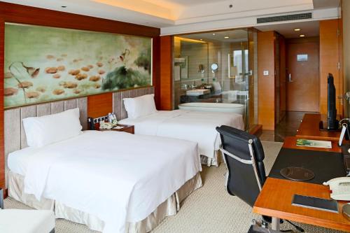 宝安观澜格兰云天国际酒店的酒店客房配有两张床和一张书桌