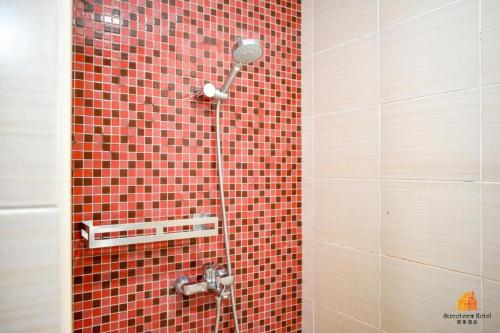 麻坡STREETVIEW HOTEL的一间带淋浴的浴室和红色瓷砖墙