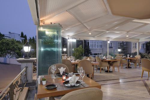 图兹拉Chatto Hotel的庭院内的餐厅,配有桌椅