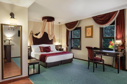 图兹拉Chatto Hotel的一间卧室配有一张床、一张书桌和一面镜子