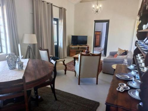 莱迪史密斯Prinspoort Klein Karoo Stay的客厅配有桌椅和电视。