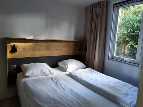 斯欣费尔德德布伦克伯格小屋公园洋房汽车旅馆的卧室设有两张单人床和窗户。