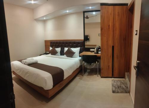 古瓦哈提Aditya Inn的一间卧室配有一张床和一张书桌