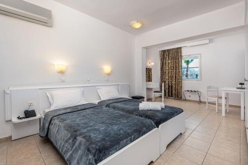 蒂加基ILIOS K Village Resort的白色卧室配有一张大床和一张桌子