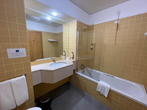 Águas SantasFlag Hotel Porto Maia的带浴缸、水槽和浴缸的浴室