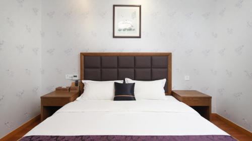 无锡花筑·无锡胜子岭客栈(灵山小镇拈花店)的卧室配有一张带两张桌子的大型白色床