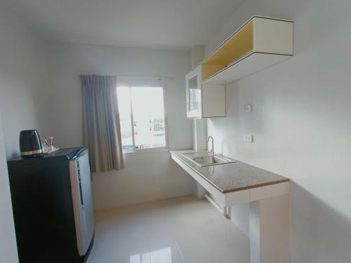 曼谷布拉索宾馆的一间带水槽和冰箱的小厨房