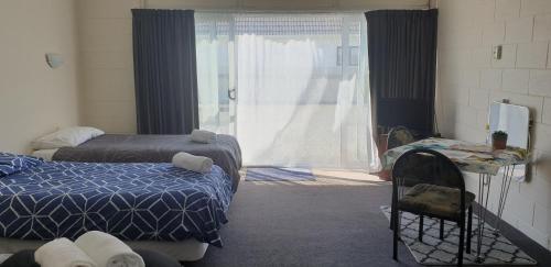 怀乌鲁Roadside Motel的客房设有两张床和大窗户。
