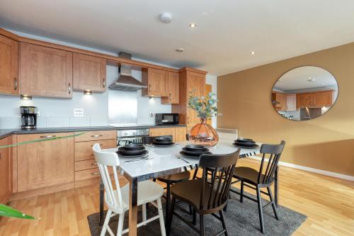 格拉斯哥Riverview Apartments的厨房配有桌椅和镜子