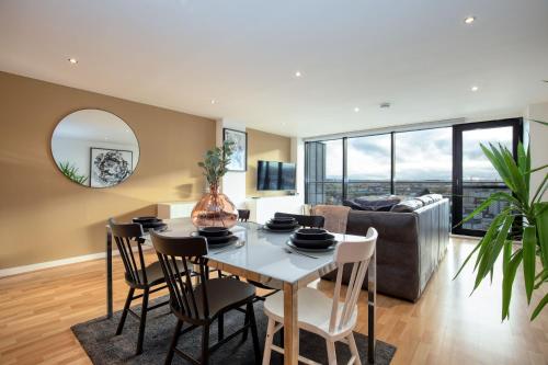 格拉斯哥Riverview Apartments的厨房以及带桌椅的起居室。